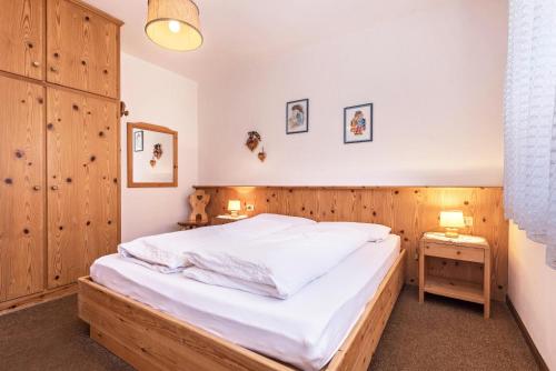 Schlafzimmer mit einem großen Bett mit einem Kopfteil aus Holz in der Unterkunft Casa Lorenz 1 in Canazei