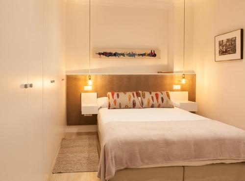 a bedroom with a large bed with two lamps at CHUECA II in Madrid