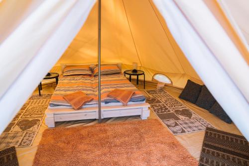 a bedroom with a bed in a tent at Natur Camp Birštonas in Birštonas