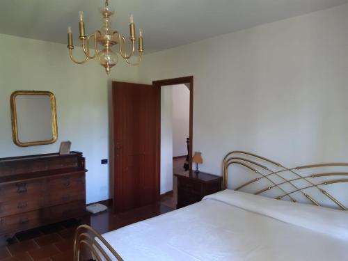 Schlafzimmer mit einem Bett, einem Spiegel und einem Kronleuchter in der Unterkunft Appartamento nel verde tra Cinque Terre e Versilia in Barbarasco