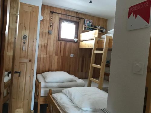 a room with two bunk beds and a window at Appartement 1 chambre, 4 personnes in Champagny-en-Vanoise