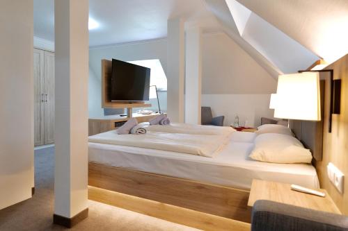 a bedroom with a large white bed and a tv at Hotel Residenz WALDOASE in Ahlbeck