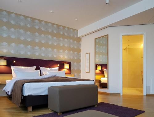 a bedroom with a large bed and a chair at Restaurant & Hotel Einhorn in Oppenweiler