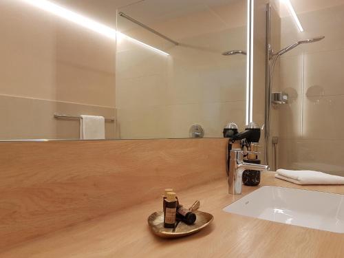 a bathroom with a sink and a mirror at Restaurant & Hotel Einhorn in Oppenweiler