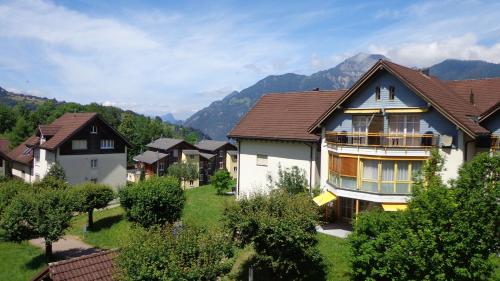 a group of houses with mountains in the background at Apart Holidays in Morschach