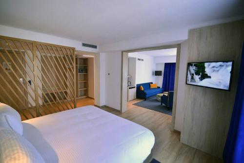 فندق رحاب  في الرباط: غرفة نوم بسرير ابيض وغرفة معيشة