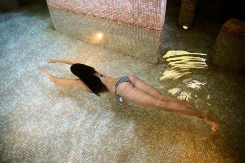 a woman laying on the floor in a swimming pool at Hotel Relais Valle Orientina in Pitigliano