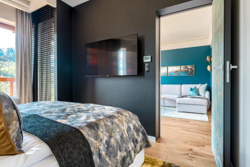 a bedroom with a bed and a sliding glass door at Tatra Resort & SPA in Kościelisko