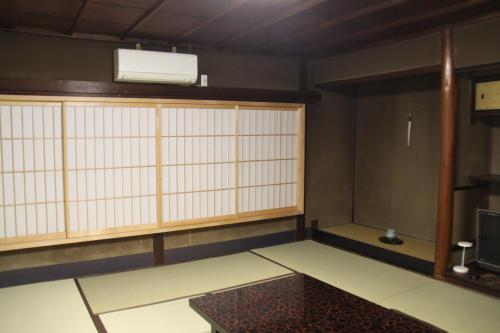 a room with a large window and a tv at Gallery Nozawa Inn in Kyoto