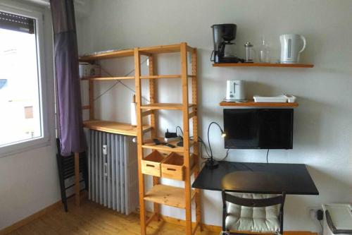 Cette chambre comprend un bureau avec un ordinateur et une étagère à livres. dans l'établissement Studio Saint-Antoine, à Chambéry