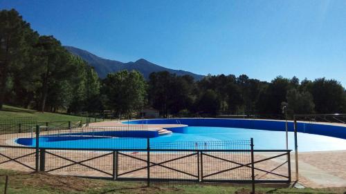 una gran piscina azul con montañas en el fondo en LA CASA DE LA ABUELA DESI, en Casavieja
