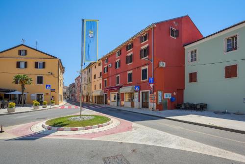 an empty street with colorful buildings in a city at Apartments Dante in Umag