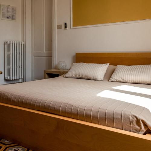 a bedroom with a large bed with a wooden frame at Arena Alfieri B&B in Livorno