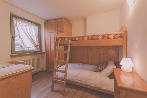 sypialnia z łóżkiem piętrowym i biurkiem w obiekcie RTA Torre Del Brenta w Madonna di Campiglio