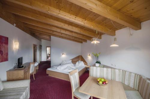 a hotel room with a bed and a table and chairs at Christophs Hotel in Schenna