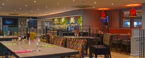 a dining room with tables and chairs in a restaurant at The Lodge Hotel in Coleraine