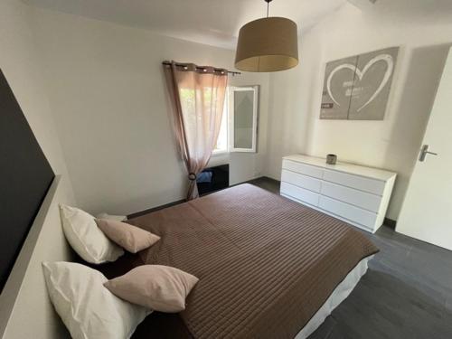 een slaapkamer met een groot bed met 2 kussens bij Maison avec jardin à 8 min de l'aéroport in Saint-Victoret