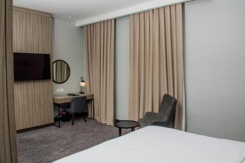 a hotel room with a bed and a desk at Radisson Lagos Ikeja in Lagos