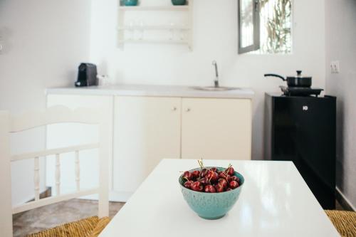 a bowl of strawberries sitting on a table in a kitchen at Exi Sea Side Suites in Perissa