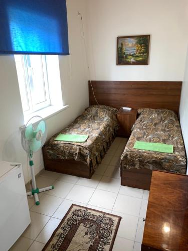 PyatikhatkiにあるEdemのベッド2台と窓が備わる小さな客室です。