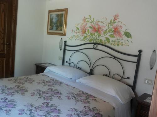a bedroom with a bed with a flower mural on the wall at B&B La Piaggia in Montemerano