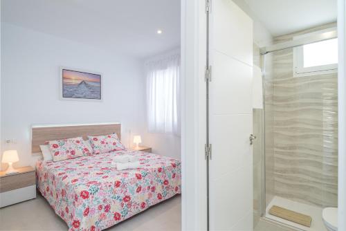 a bedroom with a bed and a glass shower at Aire Siroco - Beach Apartment 13 in Benalmádena