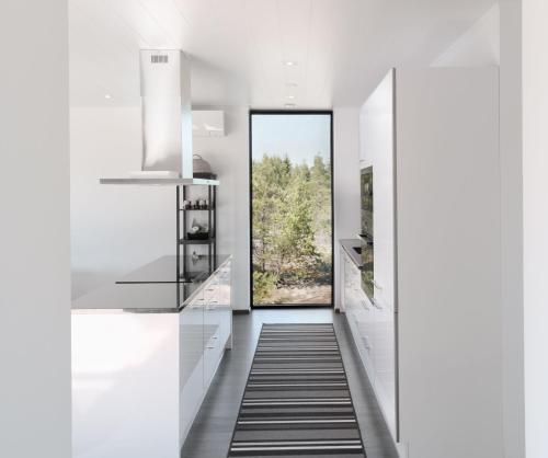 a hallway with white cabinets and a door with a window at Seija's Modern Secluded Villa with Jacuzzi & Sauna in Töfsala