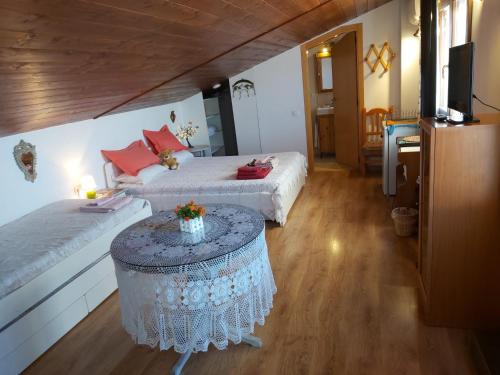 ein Schlafzimmer mit 2 Betten und einem Tisch mit Blumen darauf in der Unterkunft Casa Rural Amor Madre Tierra in Ayelo de Malferit