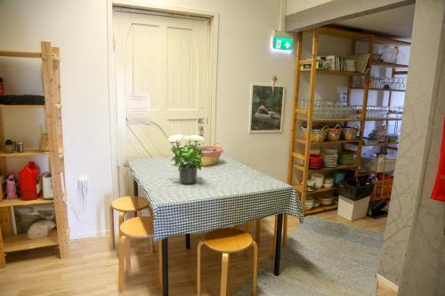 a table with chairs and a vase of flowers on it at Wanhan Aseman Majatalo in Savonlinna