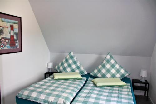2 camas individuales en una habitación con 2 almohadas en Ferienwohnung Heimelich en Rastede