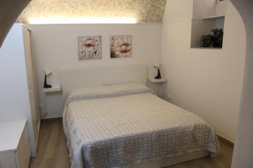 a bedroom with a bed and two pictures on the wall at Casetta Bevilacqua in Sciacca