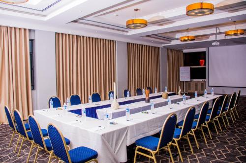 a large conference room with a long table and blue chairs at Radisson Lagos Ikeja in Lagos