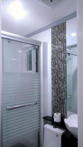 a bathroom with a shower and a toilet and a sink at Bohol South Beach Hotel in Panglao