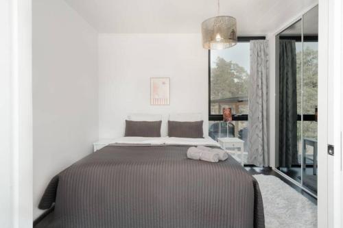 a bedroom with a bed and a large window at Seija's Modern Villa with Hot tub in Töfsala