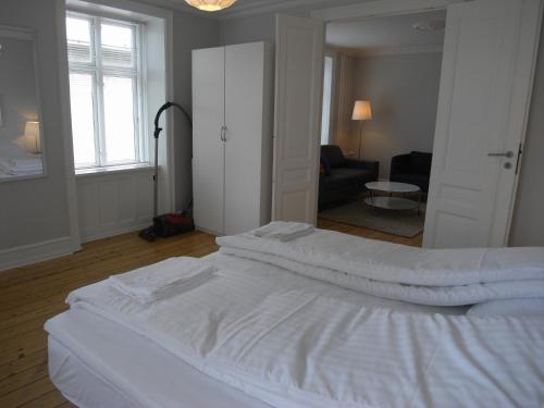 sypialnia z 2 białymi łóżkami i salonem w obiekcie Nyborggade w Kopenhadze