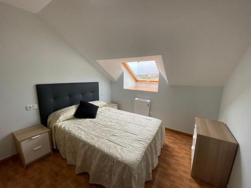 a bedroom with a bed and a window at Las Catedrales in Barreiros