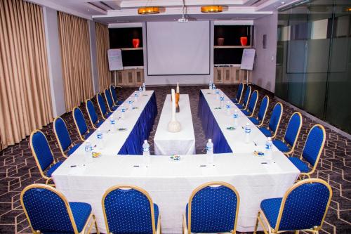 a conference room with a long table with chairs and a screen at Radisson Lagos Ikeja in Lagos