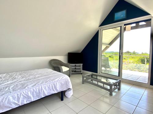 - une chambre avec un lit, une télévision et un balcon dans l'établissement REF 008 Maison T2 à Tumiac entre Océan et Golfe du Morbihan, à Arzon