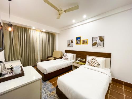 a hotel room with two beds and a couch at Sterling Marbella Dehradun in Dehradun