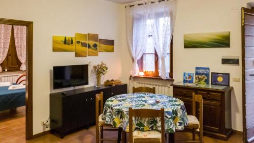 a living room with a table and a bedroom at Vacanze Sant Andrea in Paciano