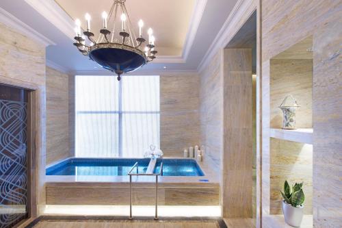a swimming pool in a room with a chandelier at Wanda Vista Changsha in Changsha