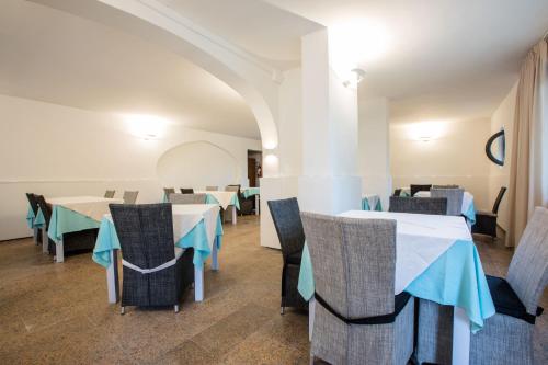 a dining room with tables and chairs in a building at Hotel La Tavernetta dei Ronchi in Marina di Massa