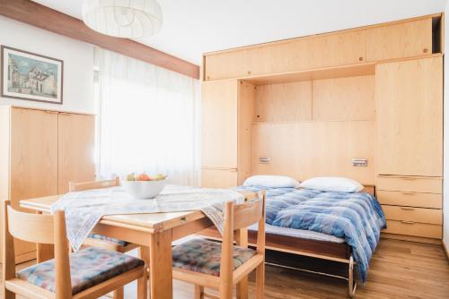 a dining room with a bed and a table and chairs at Residence Dolomia in Pozza di Fassa