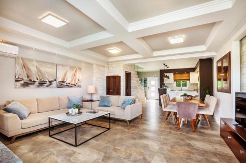 ein Wohnzimmer mit einem Sofa und einem Tisch in der Unterkunft Sunny Villas Resort & Spa in Chaniotis