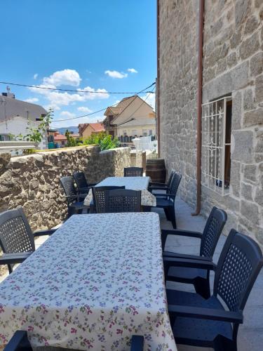 a patio with tables and chairs and a stone wall at Casa Rural del Tío Maino in Becerril de la Sierra