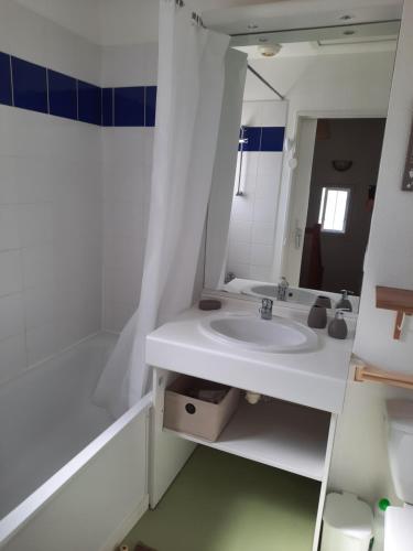 une salle de bain blanche avec un lavabo et un miroir dans l'établissement Belle maisonnette dans résidence avec piscine, à Soulac-sur-Mer