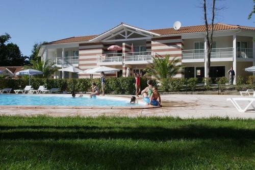 un groupe de personnes assises dans une piscine dans l'établissement Belle maisonnette dans résidence avec piscine, à Soulac-sur-Mer