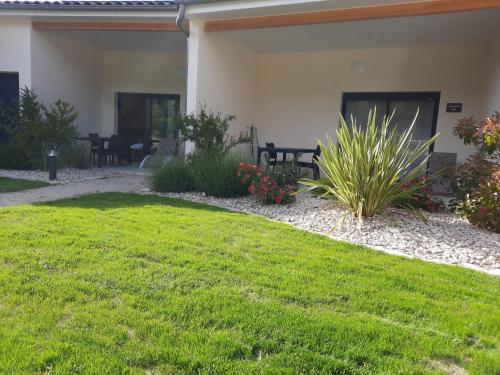 a house with a yard with grass and plants at Le Logis de Bérianne in Les Tourrettes