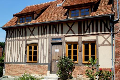 an old house with a wooden door and windows at Hôtel La Licorne & Spa in Lyons-la-Forêt