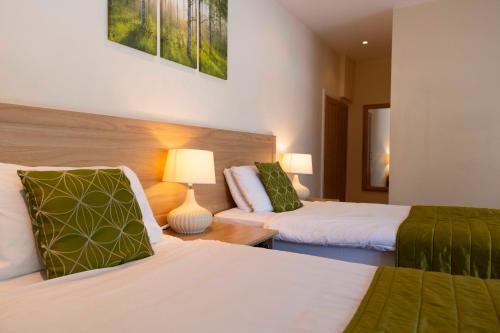 a hotel room with two beds and a couch at The Limes Country Lodge Hotel & Admiral Restaurant in Solihull